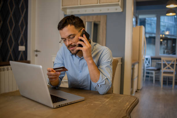 istock Man using his credit card to shop online 1459457149
