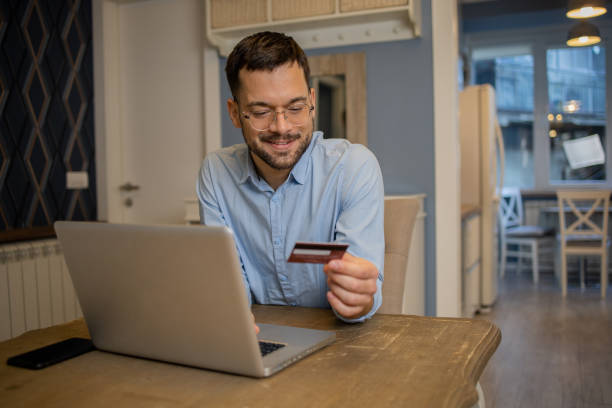 istock Cheerful man doing online shopping 1459457161