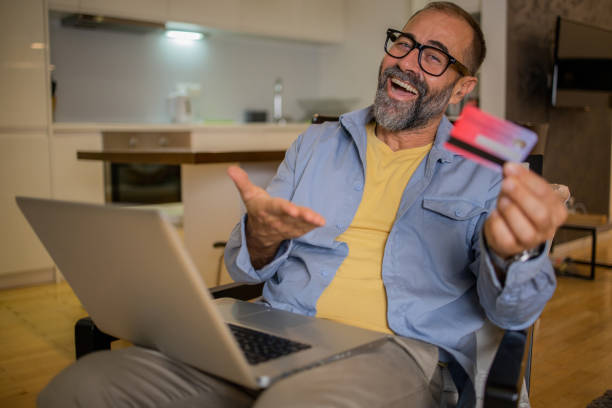 istock Cheerful man doing online shopping 1459457250