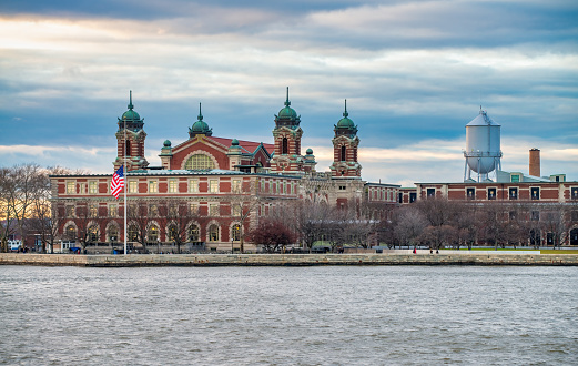 New York City, NY - December 3rd, 2018: Sunset view of Ellis Island from Hudson River.