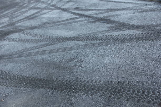 istock Vehicle tyre marks on icy asphalt 1459458083