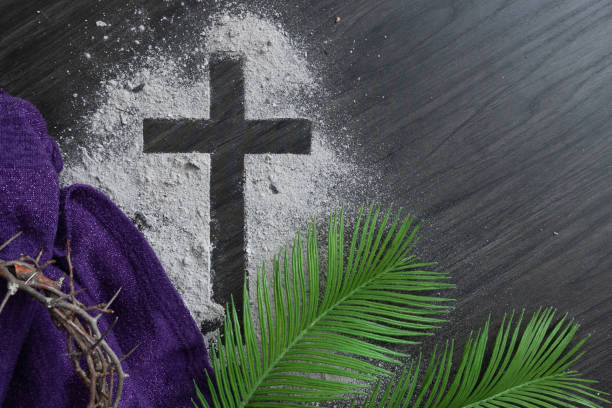 Cross of ashes, palms and crown of thorns with purple cloth stock photo