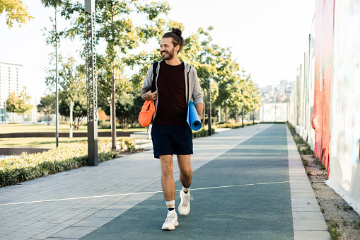 Portrait of a happy young man going to exercise outdoors
