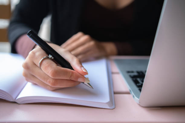 istock Crop woman making notes near laptop 1459472007