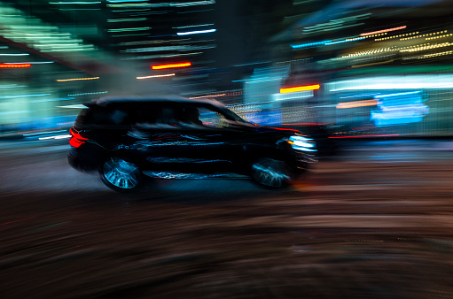 Blurred motion: Car and driver in silhouette