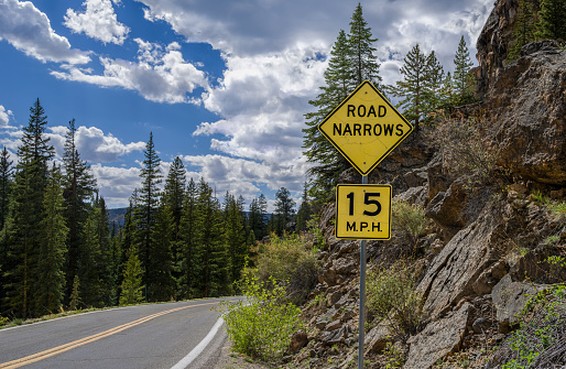 A weathered sign warns of changing road conditions along the route through Independence Pass in central Colorado.