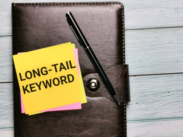 word long tail keyword written on sticky note with a pen. - tail long marketing internet imagens e fotografias de stock