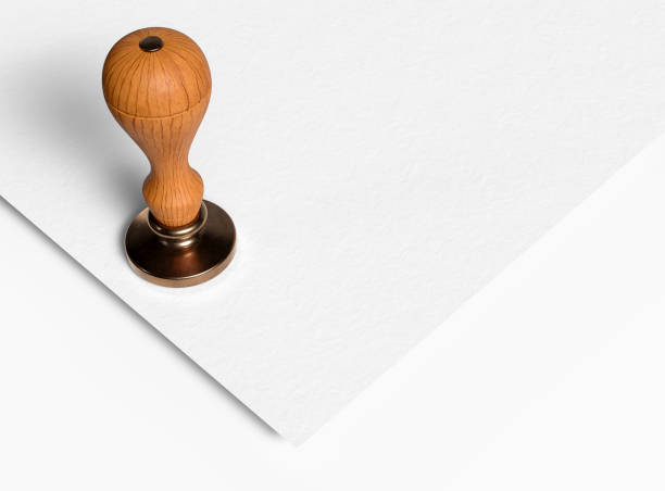 Bell metal head stamp tool with wooden handle on white paper