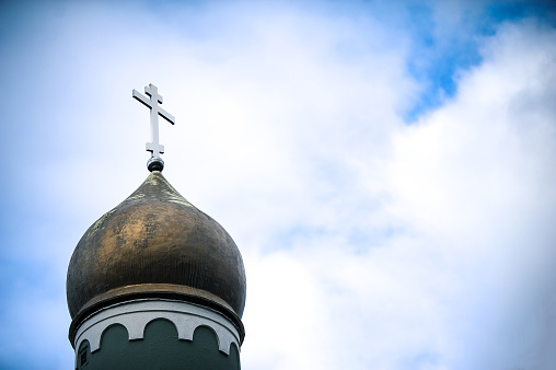 Golden domes with a cross of the Orthodox Church of Ukraine on a background of blue sky. Religion.