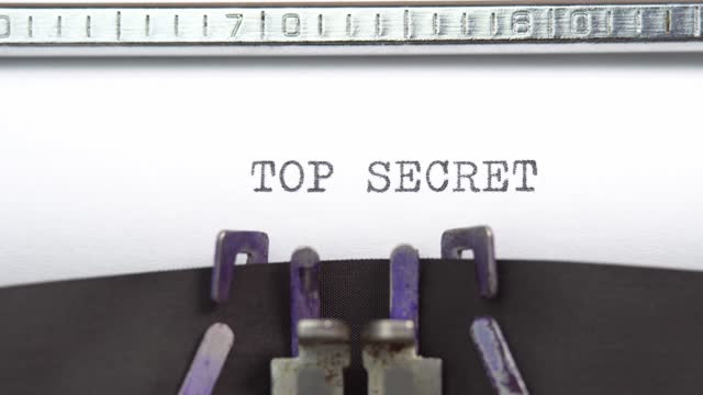 Top Secret phrase closeup being typing and centered on a sheet of paper on old vintage typewriter mechanical