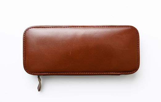Close-up of closed men's travel hygiene products leather case on white background.