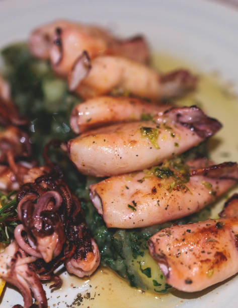 istock Fried grilled baby squids on a plate with garlic, lemon and mashed potato garnish served in a traditional seafood restaurant in Montenegro, prepared cooked calamari on a table 1459500414