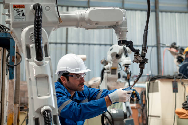 istock Engineer factory industry wearing safety uniform work and checking system of the welding robots for welding steel electrical by control system robot automate for industry manufacture concept. 1459502485