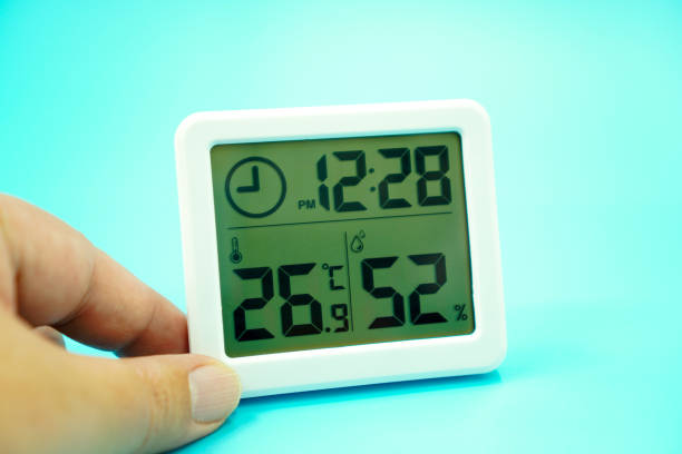 istock Image showing temperature, humidity and time measuring device on a blue background, close up. 1459503692