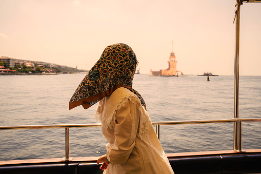 asian muslim Woman standing on the beach and looking at Maiden's Tower.