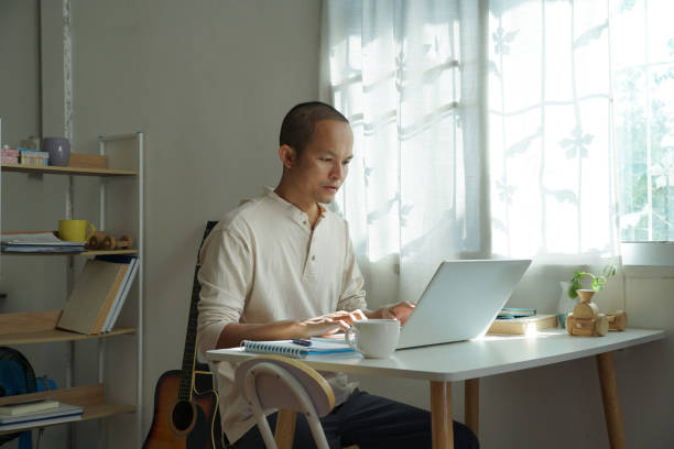 istock asian men working from home. using laptop for connecting to office system. 1459509359