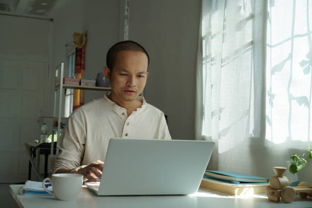 istock asian men working from home. using laptop for connecting to office system. 1459509517