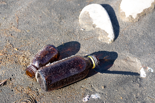 An empty glass bottles washed up on the beach