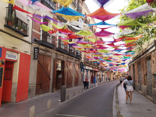 People walking on the sidewalks at Calle de la Cava Baja, a famous street with many tapas restaurants in central Madrid, Spain.
