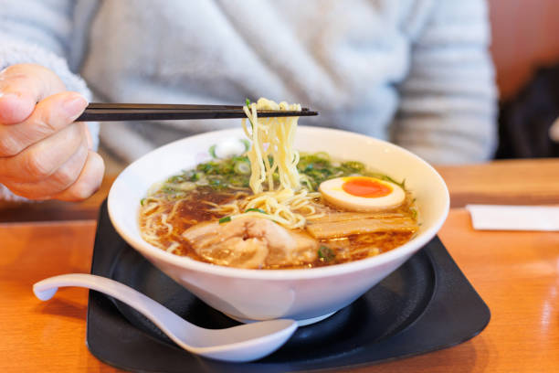 picking soy sauce ramen with chopsticks