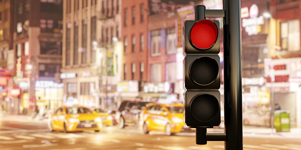 Traffic Red Light concept. Semaphore traffic stoplight on pole with red stop signal on blur city at night background. Danger warning for driver. 3d render