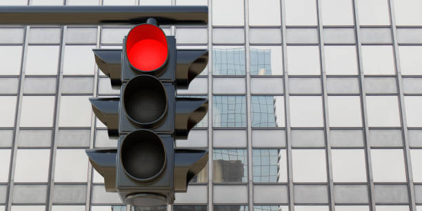 istock Hanging Traffic Red Light, red stop signal on skyscraper background. Under view. 3d render 1459525940