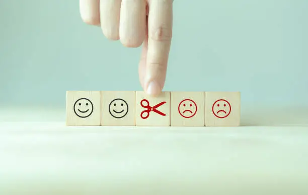 Photo of Reducing dissatisfied customers, managing complaints and claims. Bad ratings, bad reviews, customer dissatisfaction, angry. Wooden cube with negative, depression, sadness, mental problem, stress icon.