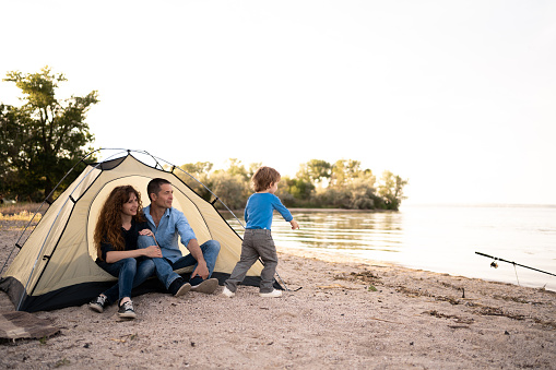 family camping near lake, freedom and happy childhood. camping, tourism, hiking and people concept