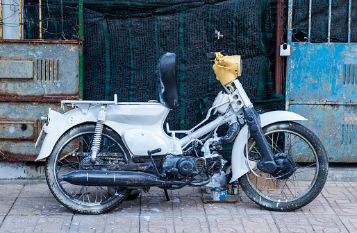 Nha Trang, Vietnam - October 19, 2019: An old Honda Cub scooter is casually painted white.