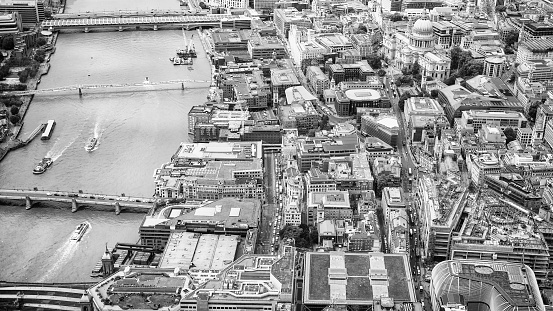 An aerial view, taken from an aircraft flying over the south of London, looking north towards St Paul's Cathedral (at the left of the image), and across to the cluster of modern towers in the City of London, the capital's main business and finance district.