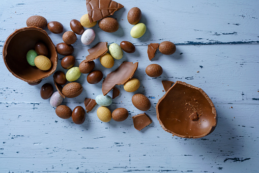 Easter composition with chocolate eggs on blue wooden background