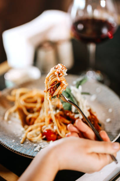 istock Woman eating spaghetti at restaurant 1459540427