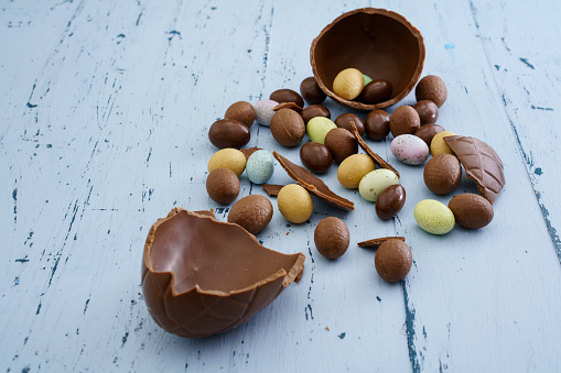 Easter composition with chocolate eggs on blue wooden background