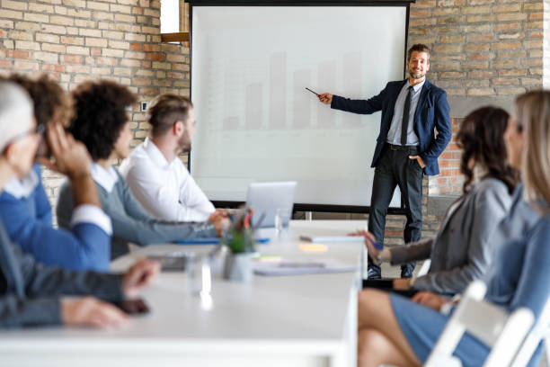 istock Happy CEO giving presentation to his colleagues in board room. 1459540903