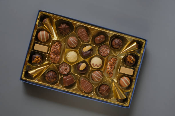 istock Assorted chocolate candies in a box on a gray background. Chocolate box. Milk chocolate candy.Sweets and desserts.Sweets box in assortment 1459541531