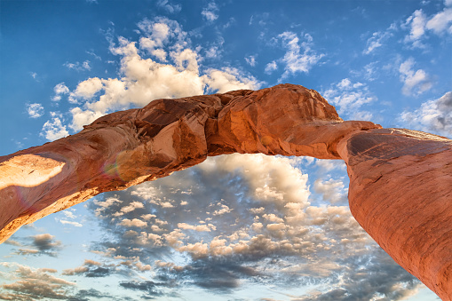 Skyward view of Delicate Arch in the Arches National Park. Rock formation and blue sky at sunset.