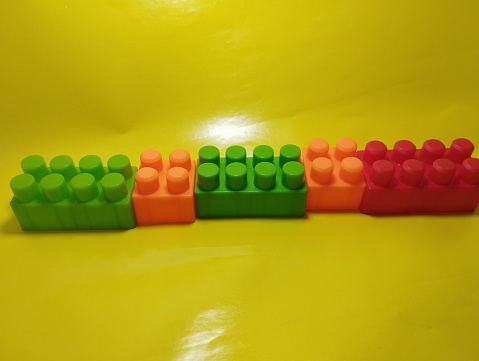 Building blocks against yellow background. children toys