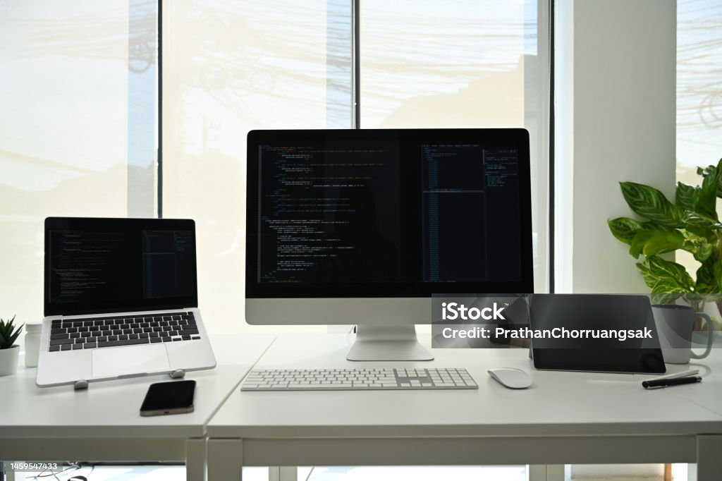Computer Monitors With Programming Code On White Office Desk At ...