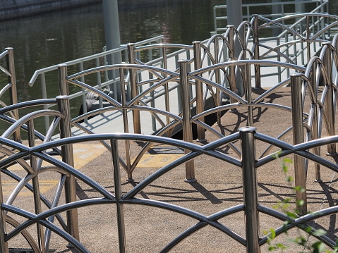 Silver-gray iron railings and a gray-brown water canal with white light used as the background.