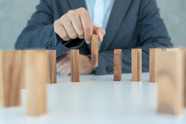 insurance with hands protect domino. Businessman hands stop dominoes falling in business crisis. business risk control and planning and strategies to run prevent insurance businesses. el seguro con manos protege a domino. las manos de los empresarios detienen la caída del dominó en la crisis empresarial. el control de riesgos empresariales y la planificación y las estrategias para ejecutar previenen los negocios de seguros.