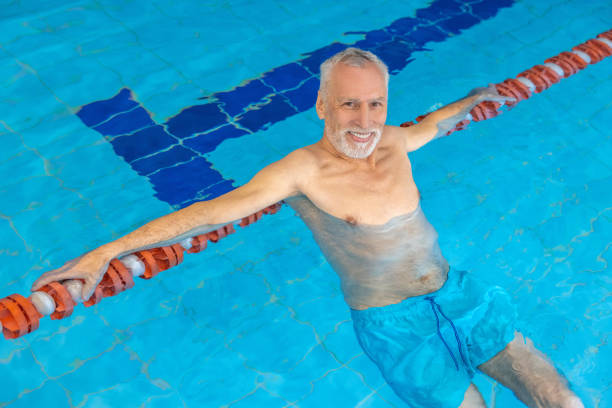 istock Gray-haired bearded swimmer looking contented at the swimming pool 1459548825