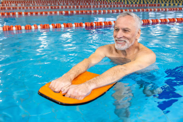 istock Smiling senior gray-haired man swimming 1459548846