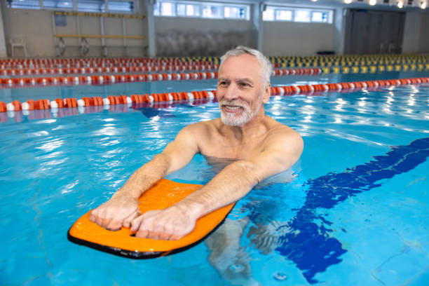 istock Smiling senior gray-haired man swimming 1459548905