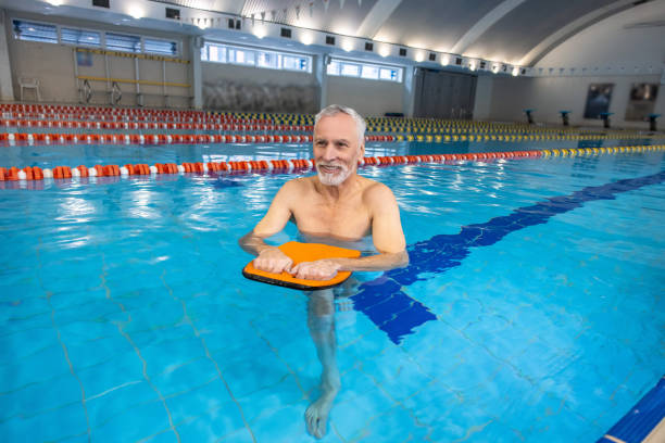 istock Smiling senior gray-haired man swimming 1459548914