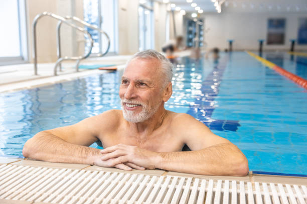 istock Gray-haired bearded swimmer looking contented at the swimming pool 1459548992
