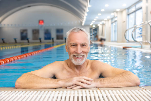 istock Gray-haired bearded swimmer looking contented at the swimming pool 1459549067