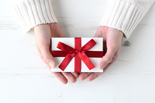 Woman's hands giving present box