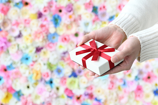 Woman's hands giving present box