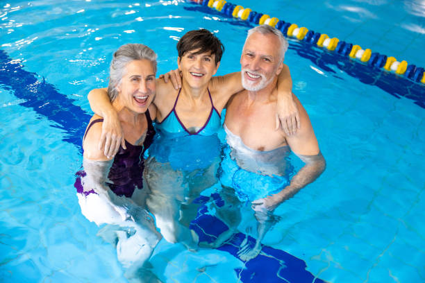 istock Three seniors looking happy standing in the swimming pool 1459551086