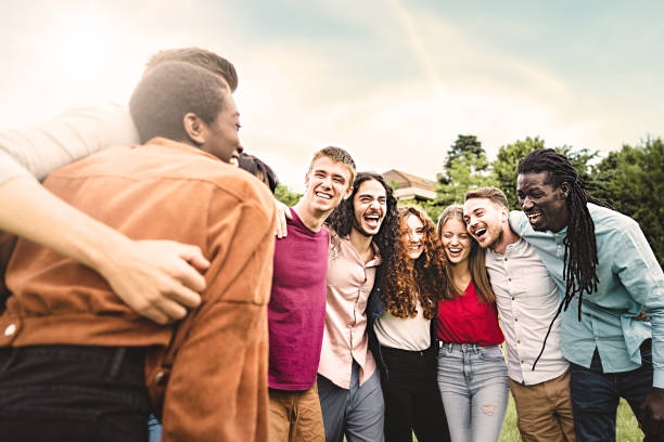 istock Multiethnic group of joyful young people having fun hugging together walking laughing and interacting together arm on shoulders in the park 1459552980